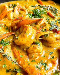 Butter shrimp curry garnished with cilantro and cream swirl