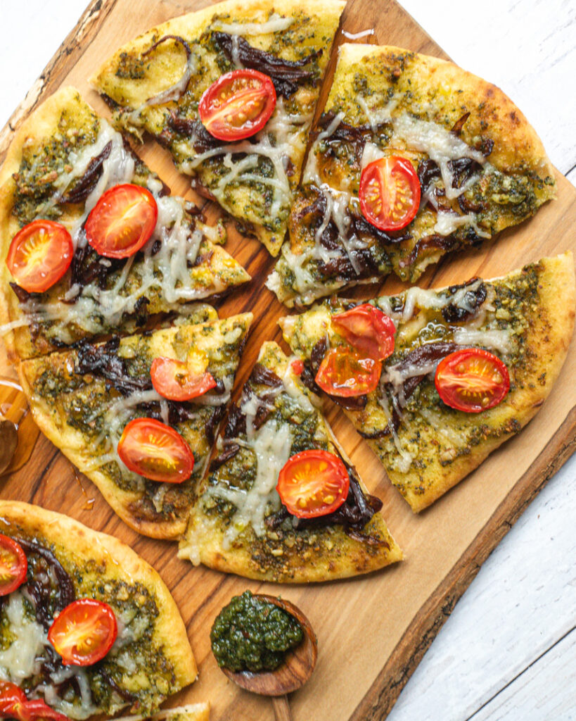 Basil pesto naan baked in a tandoor, topped with fresh herbs and olive oil.